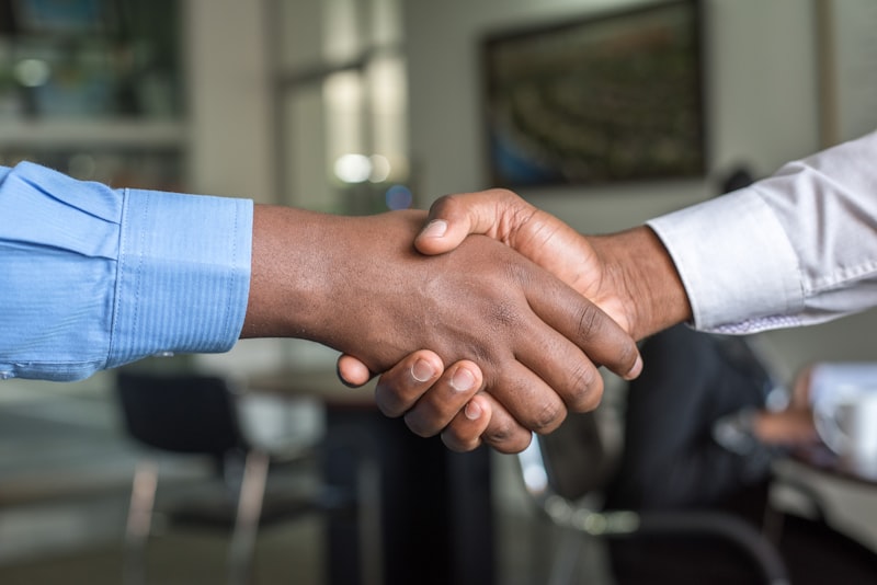 Two people shaking hands across a table